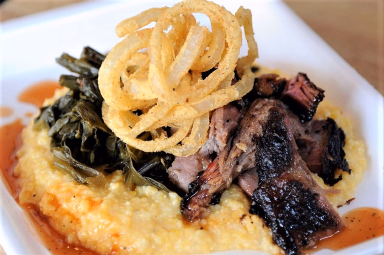 SAW's Soul Kitchen signature dishes Pork & Greens (smoked pulled pork over cheese grits, topped with collard greens), Sweet Tea Fried Chicken Sandwich, and Smoked Wings.